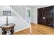 Interior entryway featuring hardwood floors, a staircase, and an elegant side table at 6990 Old Hunt Club Rd, Zionsville, IN 46077