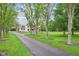 Beautiful home with mature trees lining the long driveway and manicured front lawn at 6990 Old Hunt Club Rd, Zionsville, IN 46077