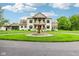 Elegant two-story home with a circular driveway, fountain, and a well-manicured lawn at 6990 Old Hunt Club Rd, Zionsville, IN 46077