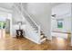 Bright foyer with wood floors, a staircase, and an entry to another room at 6990 Old Hunt Club Rd, Zionsville, IN 46077