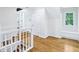 Upper hallway landing area with hardwood floors, white trim, and natural light, enhancing the home's spacious layout at 6990 Old Hunt Club Rd, Zionsville, IN 46077