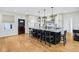 Open-concept kitchen with a large island, modern pendant lights, and sleek black chairs at 6990 Old Hunt Club Rd, Zionsville, IN 46077