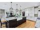 Spacious kitchen island with seating, pendant lighting, and view into dining area at 6990 Old Hunt Club Rd, Zionsville, IN 46077