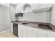 A kitchenette boasts white cabinets, granite countertops, and a built-in microwave for convenience at 6990 Old Hunt Club Rd, Zionsville, IN 46077