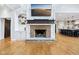Cozy living room with brick fireplace, hardwood floors, and built-in shelving at 6990 Old Hunt Club Rd, Zionsville, IN 46077