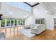 Bright and open living room featuring high ceilings, skylights, hardwood floors, and access to the backyard at 6990 Old Hunt Club Rd, Zionsville, IN 46077