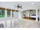Spacious living room featuring marble tile floors, ample natural light, and an open layout flowing into the bedroom at 6990 Old Hunt Club Rd, Zionsville, IN 46077