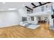 Open-concept living space with hardwood floors, high ceilings, fireplace, and upstairs balcony at 6990 Old Hunt Club Rd, Zionsville, IN 46077