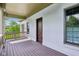 Covered porch with a brick surround and a dark stained floor at 6990 Old Hunt Club Rd, Zionsville, IN 46077