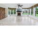 Bright sunroom featuring a brick fireplace, large windows with scenic views, and a ceiling fan at 6990 Old Hunt Club Rd, Zionsville, IN 46077