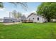 Backyard showcasing a spacious lawn, deck, and outbuildings, perfect for outdoor activities at 709 S Meridian St, Lebanon, IN 46052