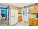 Efficient kitchen featuring light wood cabinets, white fridge, and modern flooring at 709 S Meridian St, Lebanon, IN 46052