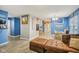 Open-concept living room with light wood-look floors, blue accent walls, and comfortable brown leather furniture at 709 S Meridian St, Lebanon, IN 46052