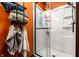 Bright bathroom featuring orange walls, a shower with glass door and a rack with neatly arranged towels at 71 S 9Th Ave, Beech Grove, IN 46107