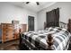 Comfortable bedroom featuring a wooden dresser, wood flooring, and a bed with a black and white patterned quilt at 71 S 9Th Ave, Beech Grove, IN 46107