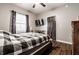 Cozy bedroom featuring hardwood floors, a ceiling fan, and a comfortable bed with a stylish black-and-white patterned quilt at 71 S 9Th Ave, Beech Grove, IN 46107