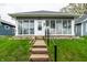 Gray single story home with a glass enclosed front porch, short walk and well-maintained lawn at 71 S 9Th Ave, Beech Grove, IN 46107