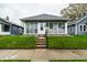 Charming single-story home featuring a glass-enclosed front porch and well-maintained lawn at 71 S 9Th Ave, Beech Grove, IN 46107