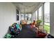 Inviting sunroom with white brick walls, hanging lights, and comfortable seating and potted plants at 71 S 9Th Ave, Beech Grove, IN 46107