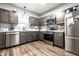Well-lit kitchen with stainless steel appliances, dark cabinets, and marble countertops at 71 S 9Th Ave, Beech Grove, IN 46107