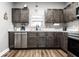 Modern kitchen with dark cabinets, stainless steel appliances, marble countertops, and natural light at 71 S 9Th Ave, Beech Grove, IN 46107