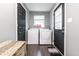 Functional laundry room with a washing machine and dryer, dark doors, and a woven basket for storage at 71 S 9Th Ave, Beech Grove, IN 46107