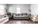 Comfortable living room with a gray sofa, leather recliner, and natural lighting from large windows at 71 S 9Th Ave, Beech Grove, IN 46107