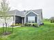 Charming home with manicured lawn, complemented by lush landscaping at 7141 Lillian Pl, Cumberland, IN 46229