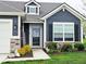 Close-up of the front entrance featuring stylish blue siding, decorative stonework and an inviting covered porch at 7141 Lillian Pl, Cumberland, IN 46229