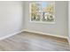 Cozy bedroom with wood-look flooring, neutral walls, and large window with natural light at 7277 Governors Row, Avon, IN 46123