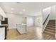 Modern kitchen features stainless steel appliances, white cabinets, and an island with a sink at 7277 Governors Row, Avon, IN 46123