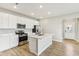 Modern kitchen features stainless steel appliances, white cabinets, and an island with a sink at 7277 Governors Row, Avon, IN 46123