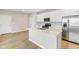 Modern kitchen features stainless steel appliances, white cabinets, and an island with a sink at 7277 Governors Row, Avon, IN 46123