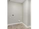 Small laundry room with gray tile floors, white walls, and plumbing for washer and dryer at 7277 Governors Row, Avon, IN 46123