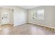 Open living room featuring wood-look flooring, neutral paint, and a view of the outdoors from the window at 7277 Governors Row, Avon, IN 46123