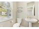 A half bath featuring a pedestal sink, open shelves, and a view to the outside at 7277 Governors Row, Avon, IN 46123