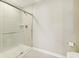 Shower with glass doors and tiled walls in neutral colors at 7277 Governors Row, Avon, IN 46123