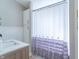 Bathroom with marble countertop vanity, storage cabinet, and charming white shower curtain with ruffle detail at 7561 N Hall School Rd, Monrovia, IN 46157