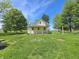 Charming yellow two-story home on a well-manicured lawn surrounded by mature trees at 7561 N Hall School Rd, Monrovia, IN 46157