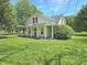 Charming yellow two-story home featuring a covered front porch and mature trees at 7561 N Hall School Rd, Monrovia, IN 46157