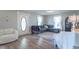 A bright living room with a gray couch, a large front door with glass, and two windows with sheer curtains at 7561 N Hall School Rd, Monrovia, IN 46157