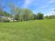 Expansive front yard featuring mature trees and the home in the background on a sunny day at 7561 N Hall School Rd, Monrovia, IN 46157
