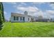 Backyard view of a house with a large lawn and fenced-in area, with a patio table and chairs at 7652 Wood Stream Dr, Indianapolis, IN 46239