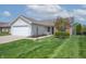Attractive home with a neatly kept lawn, flowering tree, and an attached two-car garage at 7652 Wood Stream Dr, Indianapolis, IN 46239