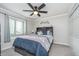 Bedroom with a ceiling fan, window, and a bed with drawer storage, complemented by neutral decor at 8140 Shorewalk Dr # C, Indianapolis, IN 46236