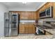 Bright kitchen with stainless steel appliances, oak cabinetry, and granite countertops at 8140 Shorewalk Dr # C, Indianapolis, IN 46236