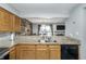 A view of the kitchen featuring granite counters, a stainless steel sink, and a pass-through to the living area at 8140 Shorewalk Dr # C, Indianapolis, IN 46236