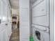 Bright laundry room with stacked washer and dryer and entry into a living room with fireplace at 8140 Shorewalk Dr # C, Indianapolis, IN 46236