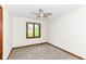 Bedroom with neutral carpet, baseboard trim, and a window overlooking greenery at 8242 Windhaven Cir, Indianapolis, IN 46236