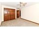 Bright bedroom features neutral carpeting, wooden closet doors, and a ceiling fan at 8242 Windhaven Cir, Indianapolis, IN 46236